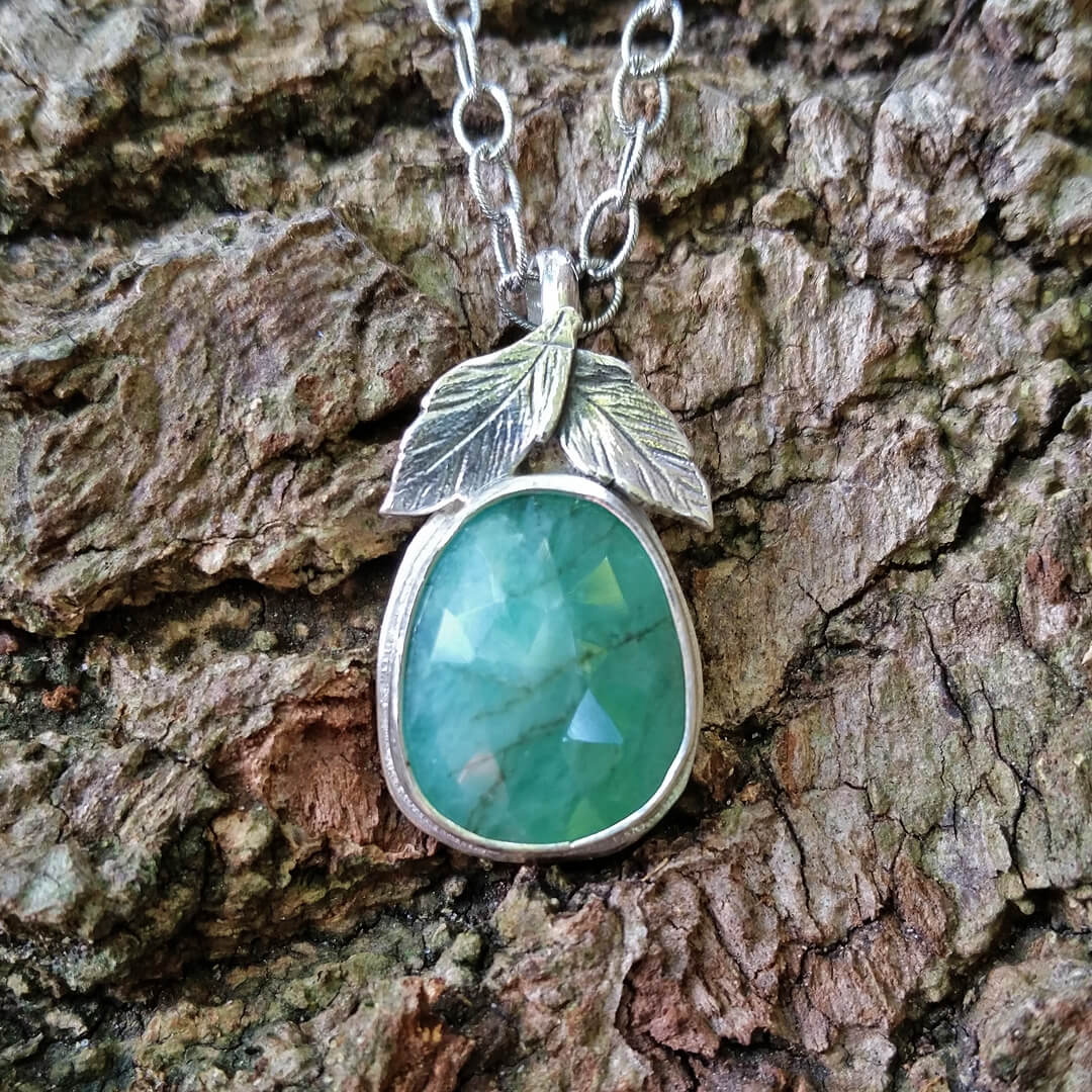 raw emerald pendant necklace with leaves in sterling silver