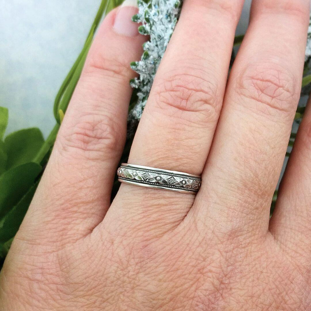Edwardian inspired vintage style women's floral wedding band in sterling silver on model