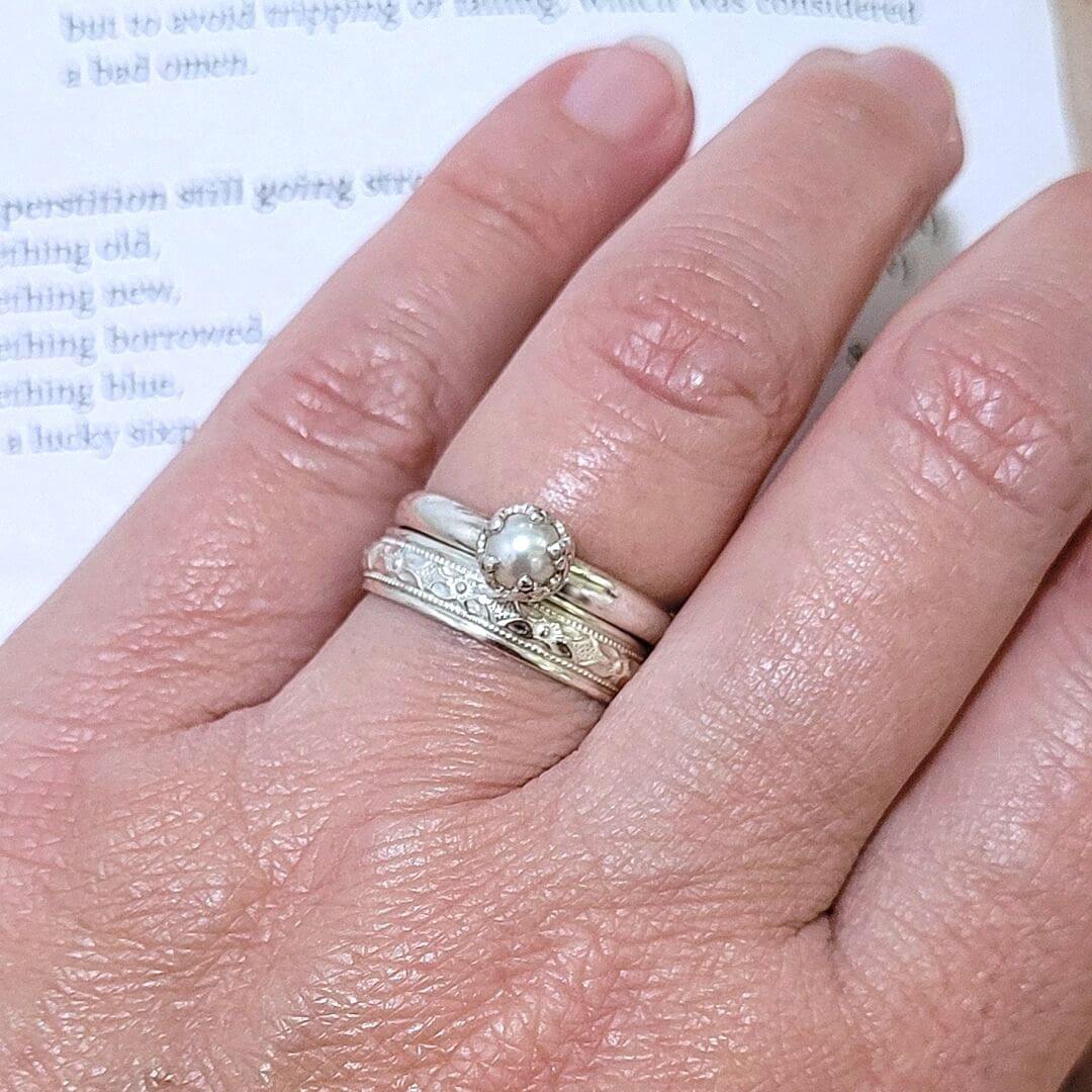 Edwardian style classic women's wedding band with Embracing Hearts Pearl Solitaire Engagement Ring in sterling Silver on model