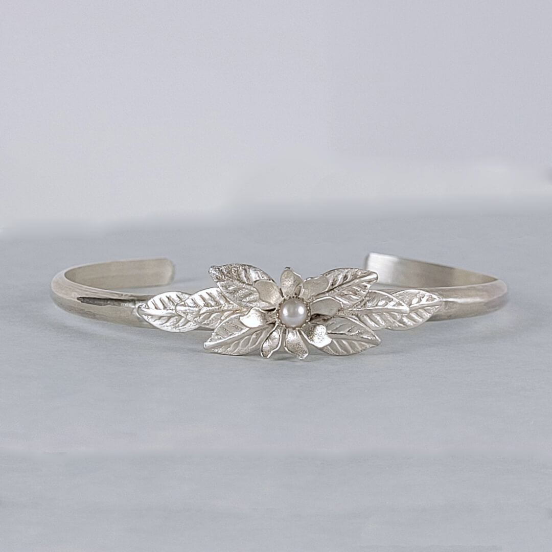 Handmade sterling silver wildflower cuff bracelet set with a cultured freshwater pearl and botanical floral design