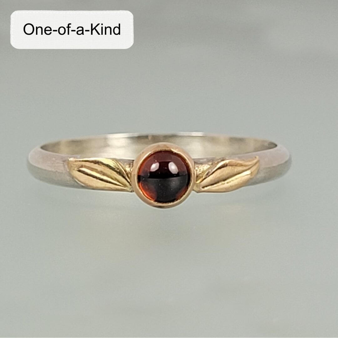 sterling silver garnet ring with 14kt gold bezel setting and gold leaves