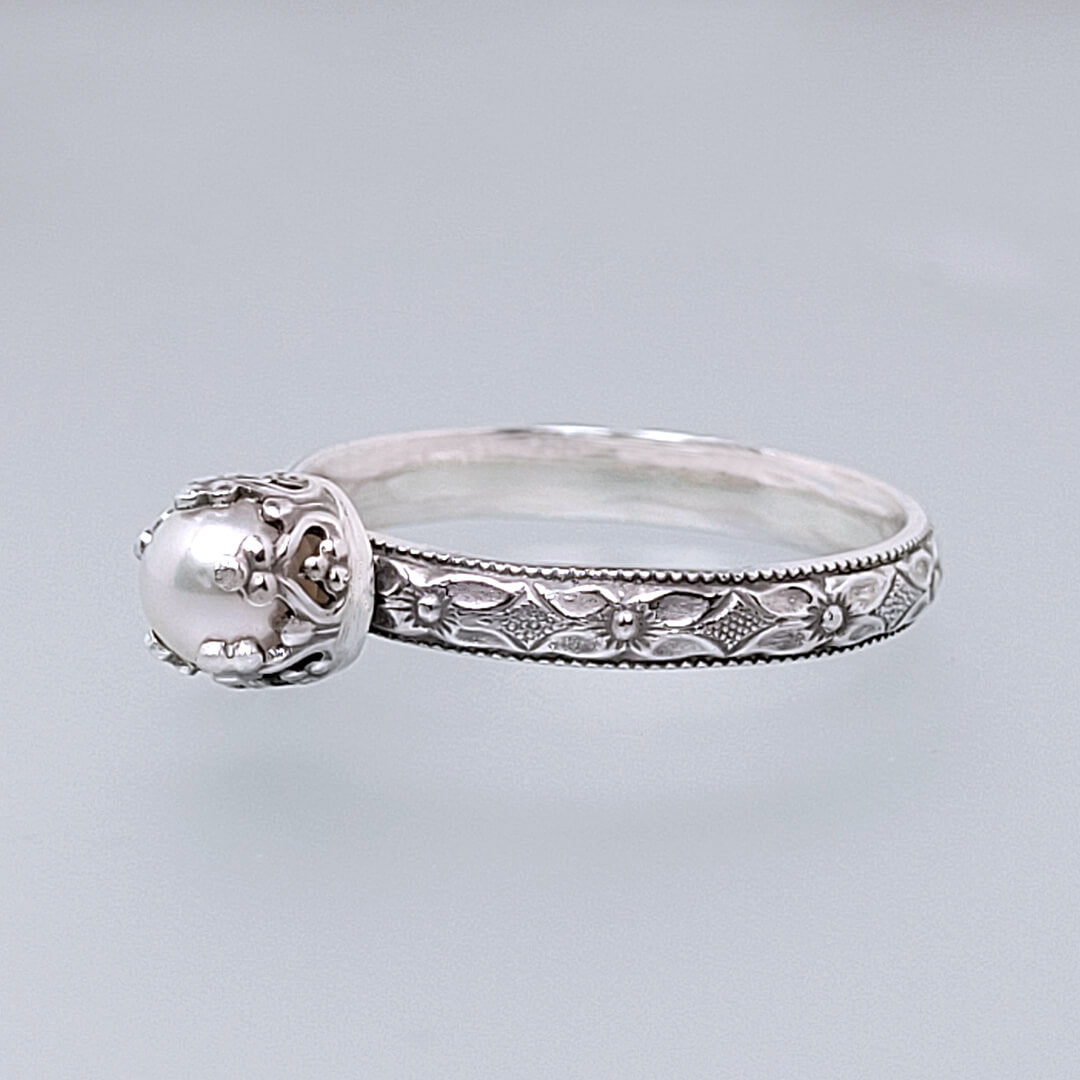 Edwardian vintage style dainty pearl engagement ring in sterling silver with textured floral band and heart-crown setting