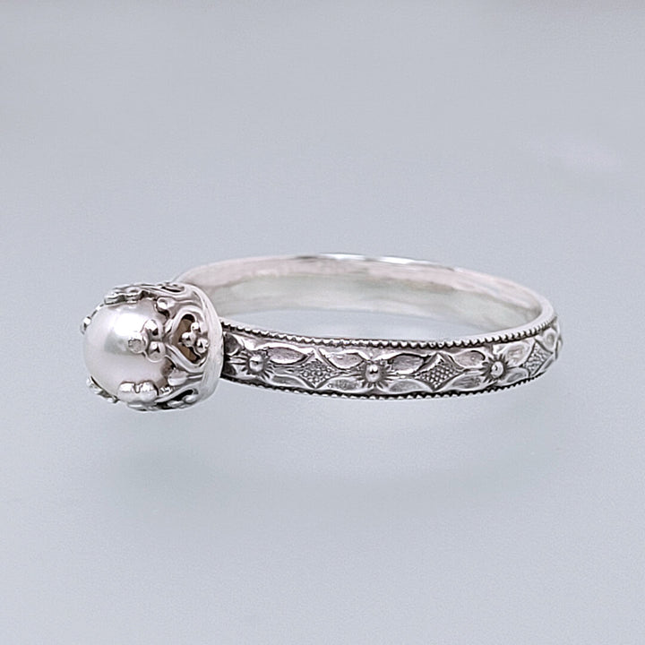 Edwardian vintage style dainty pearl engagement ring in sterling silver with textured floral band and heart-crown setting