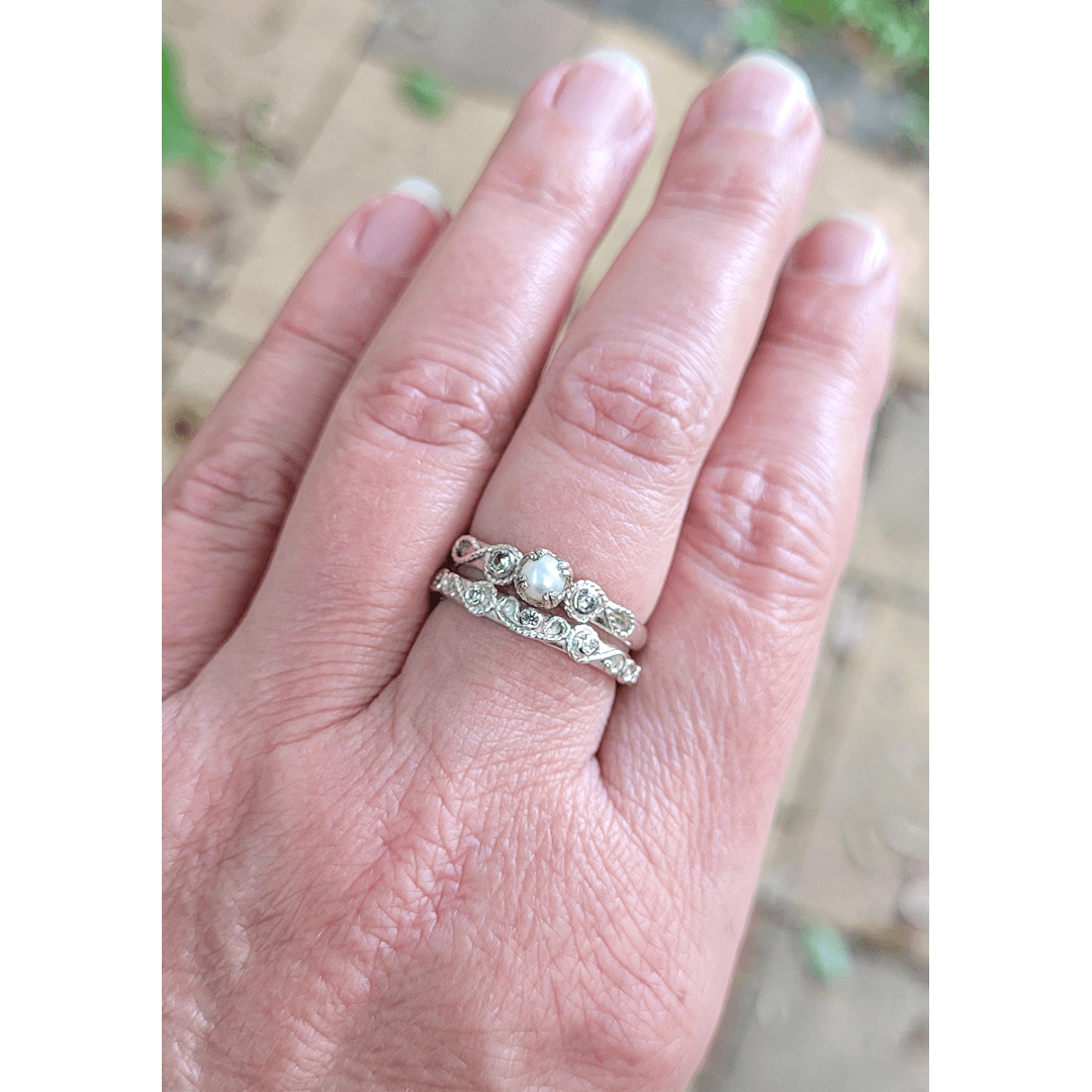 Vintage style scrollwork pearl and white sapphire engagement ring and matching scrollwork white sapphire wedding band bridal ring set in sterling silver on model