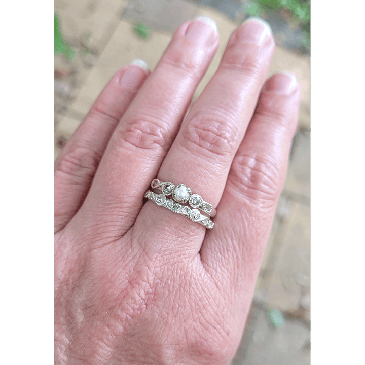 Vintage style scrollwork pearl and white sapphire engagement ring and matching scrollwork white sapphire wedding band bridal ring set in sterling silver on model