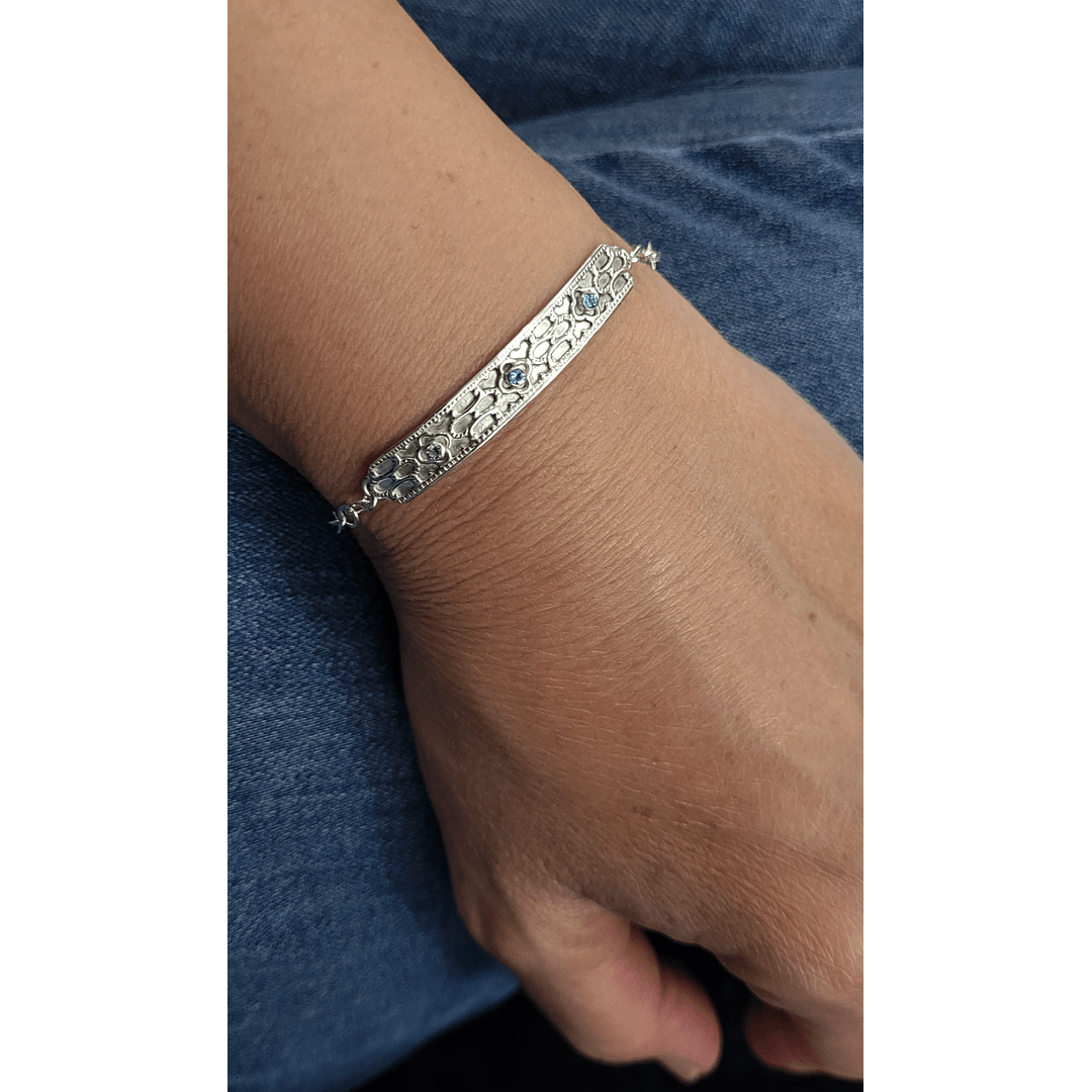 Art deco inspired sterling silver blue topaz bar bracelet worn on wrist