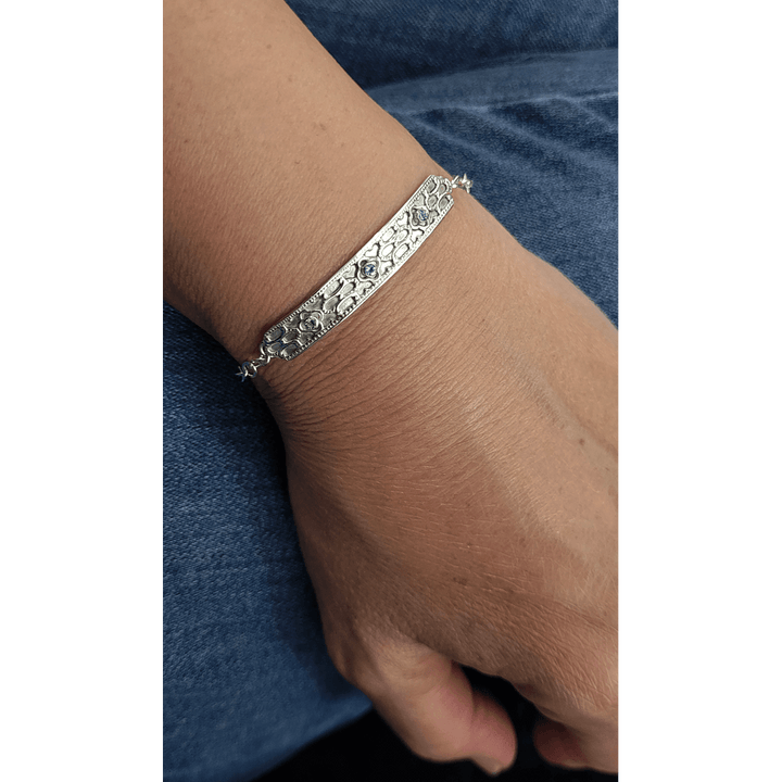 Art deco inspired sterling silver blue topaz bar bracelet worn on wrist