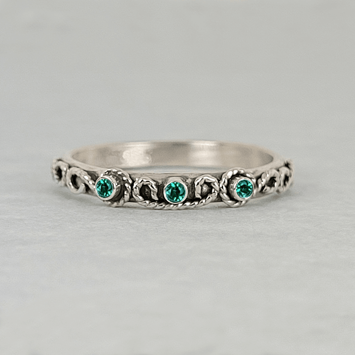 vintage-inspired scrollwork ring with emeralds in oxidized sterling silver