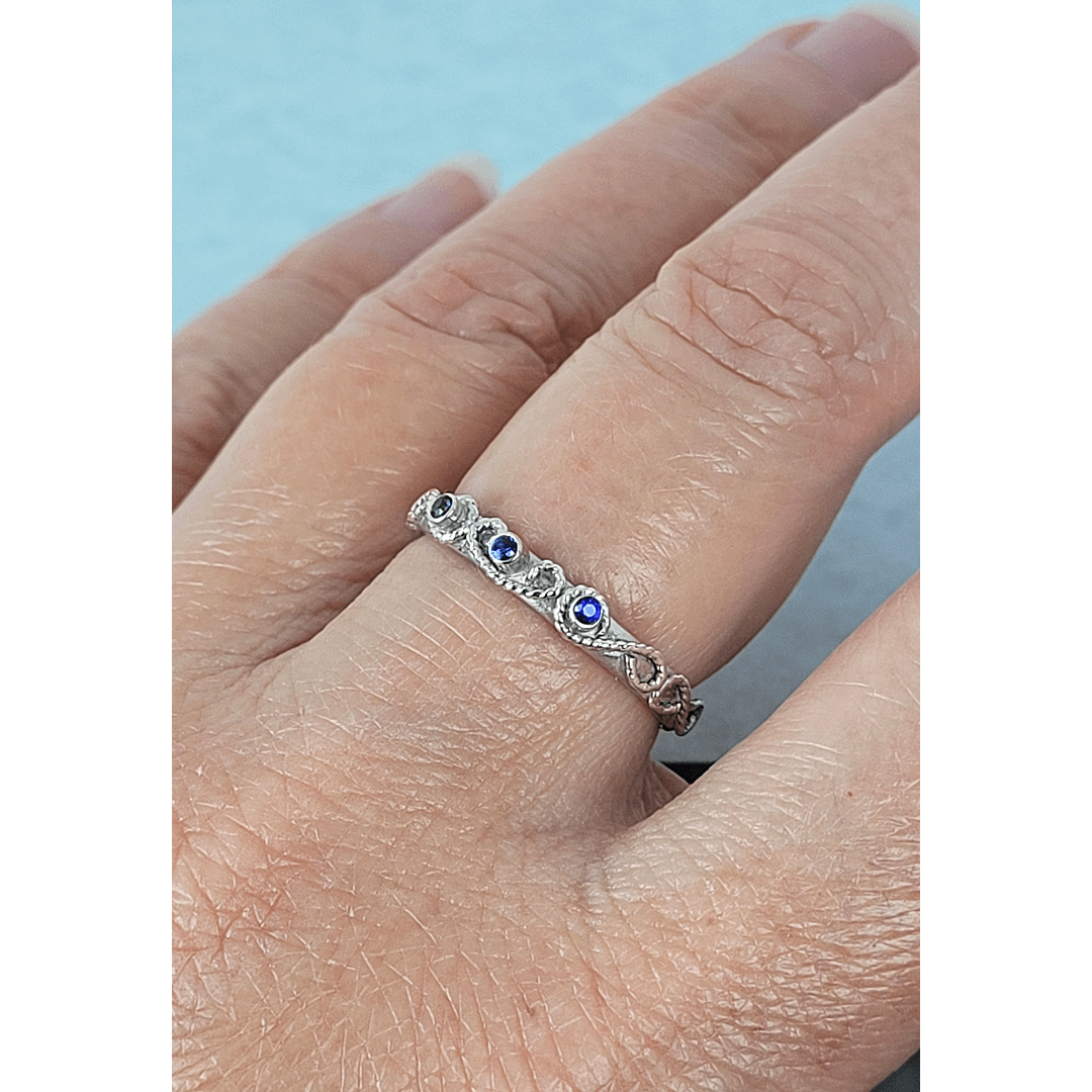 vintage-inspired scrollwork ring band with blue sapphires in sterling silver