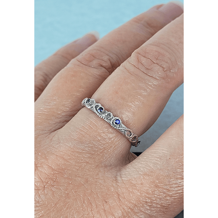vintage-inspired scrollwork ring band with blue sapphires in sterling silver