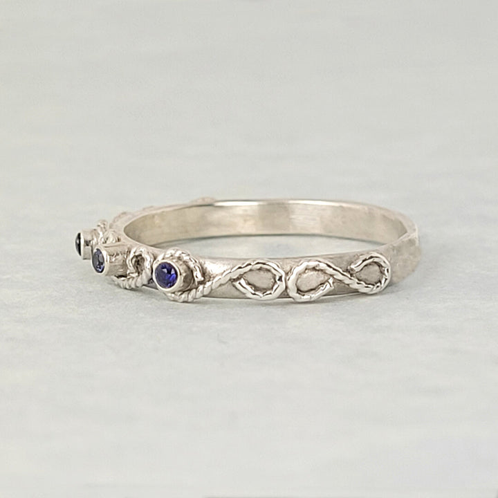 vintage-inspired scrollwork ring band with blue sapphires in sterling silver
