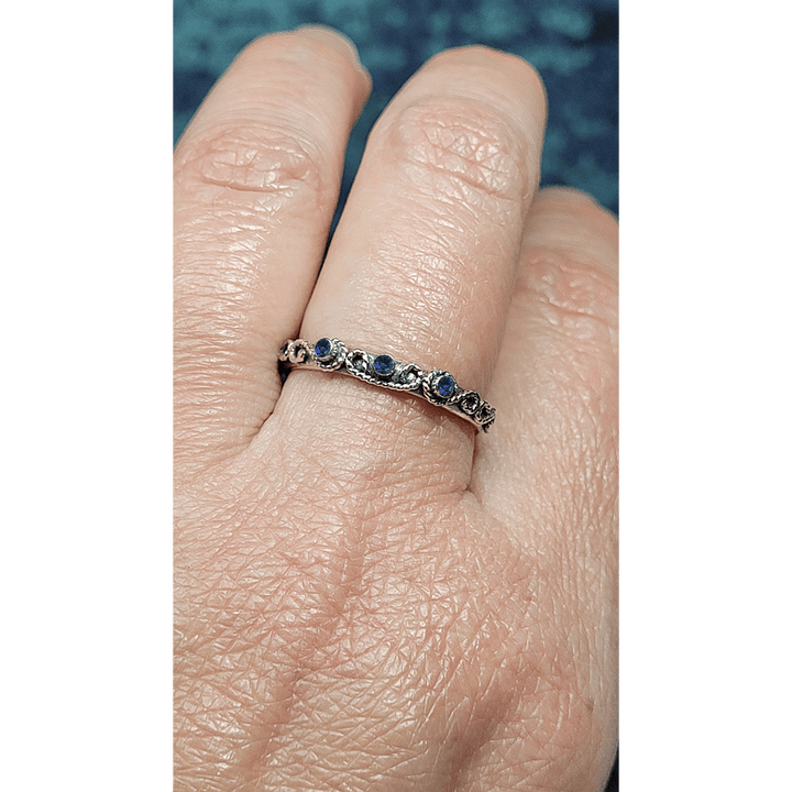 vintage-inspired scrollwork ring band with blue sapphires in sterling silver