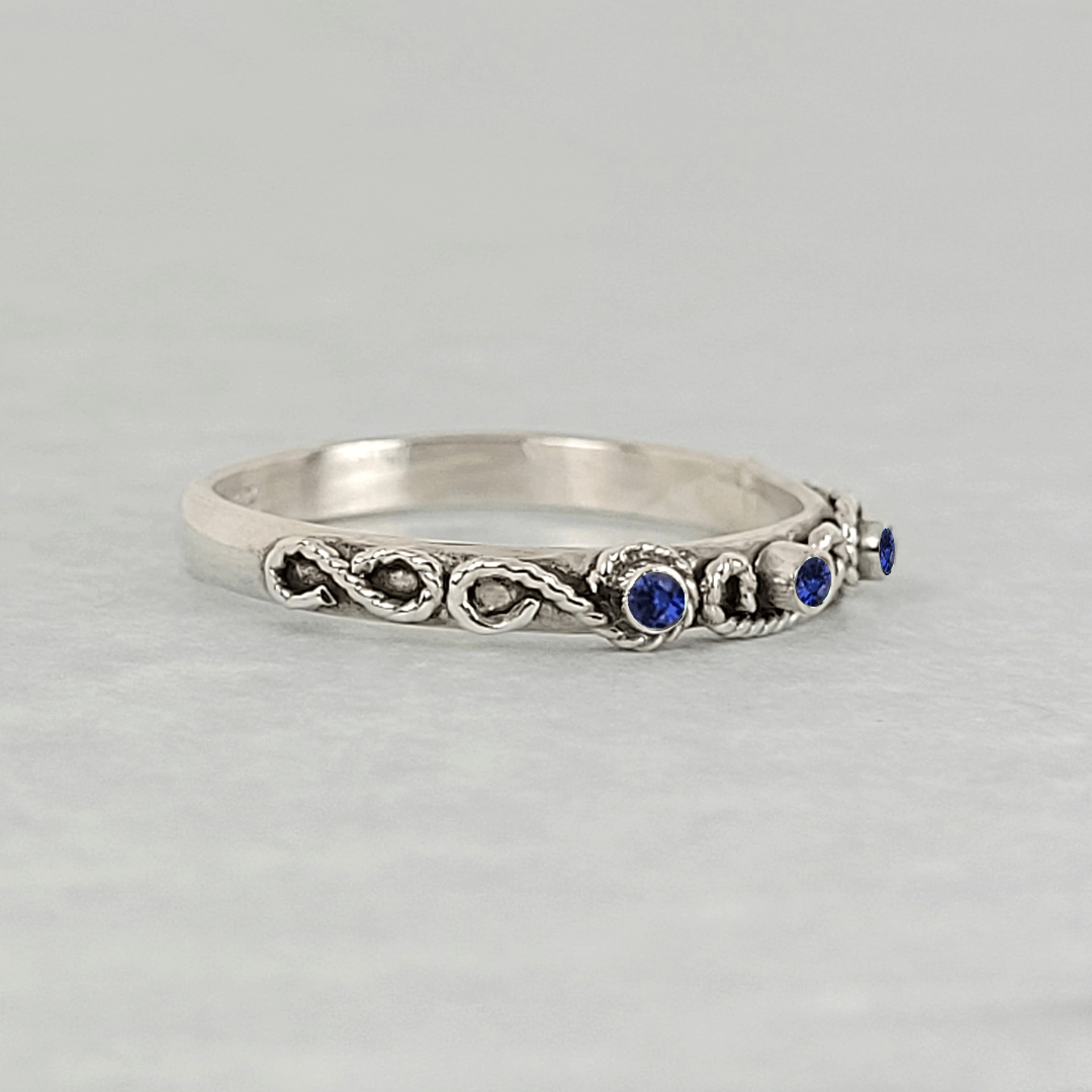 vintage-inspired scrollwork ring band with blue sapphires in sterling silver