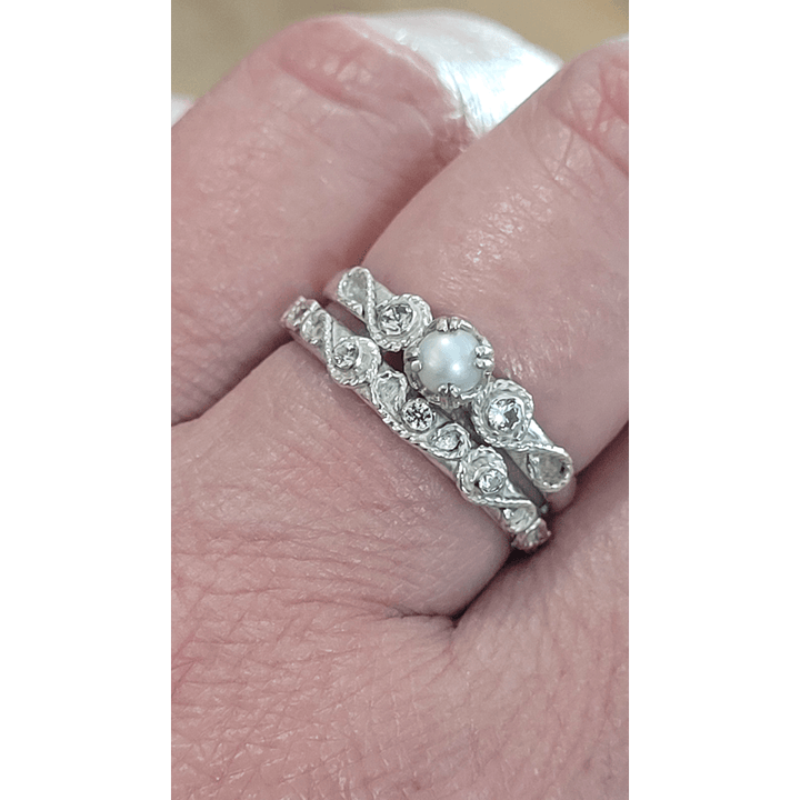 vintage style scrollwork pearl and white sapphire engagement ring and matching scrollwork white sapphire wedding band bridal ring set in sterling silver detail shot on model