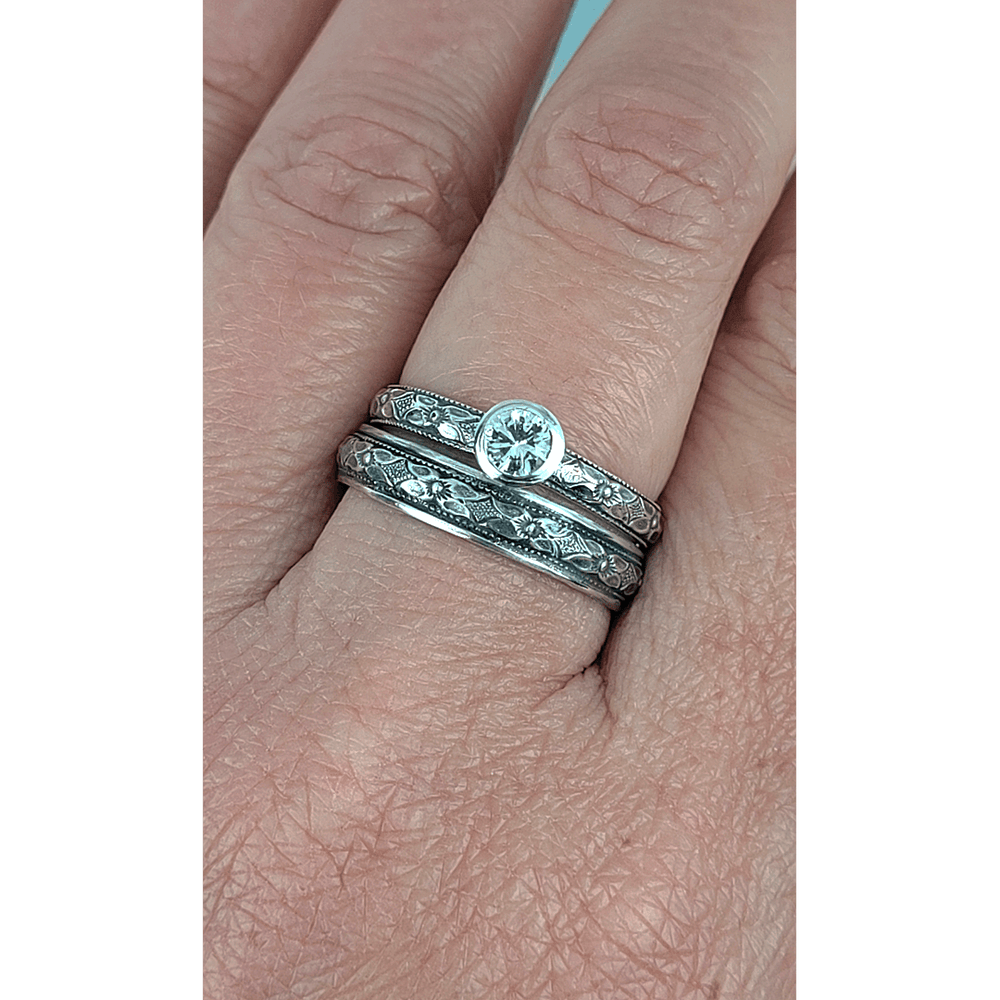 Vintage style white sapphire engagement ring and matching wedding band in sterling silver on model