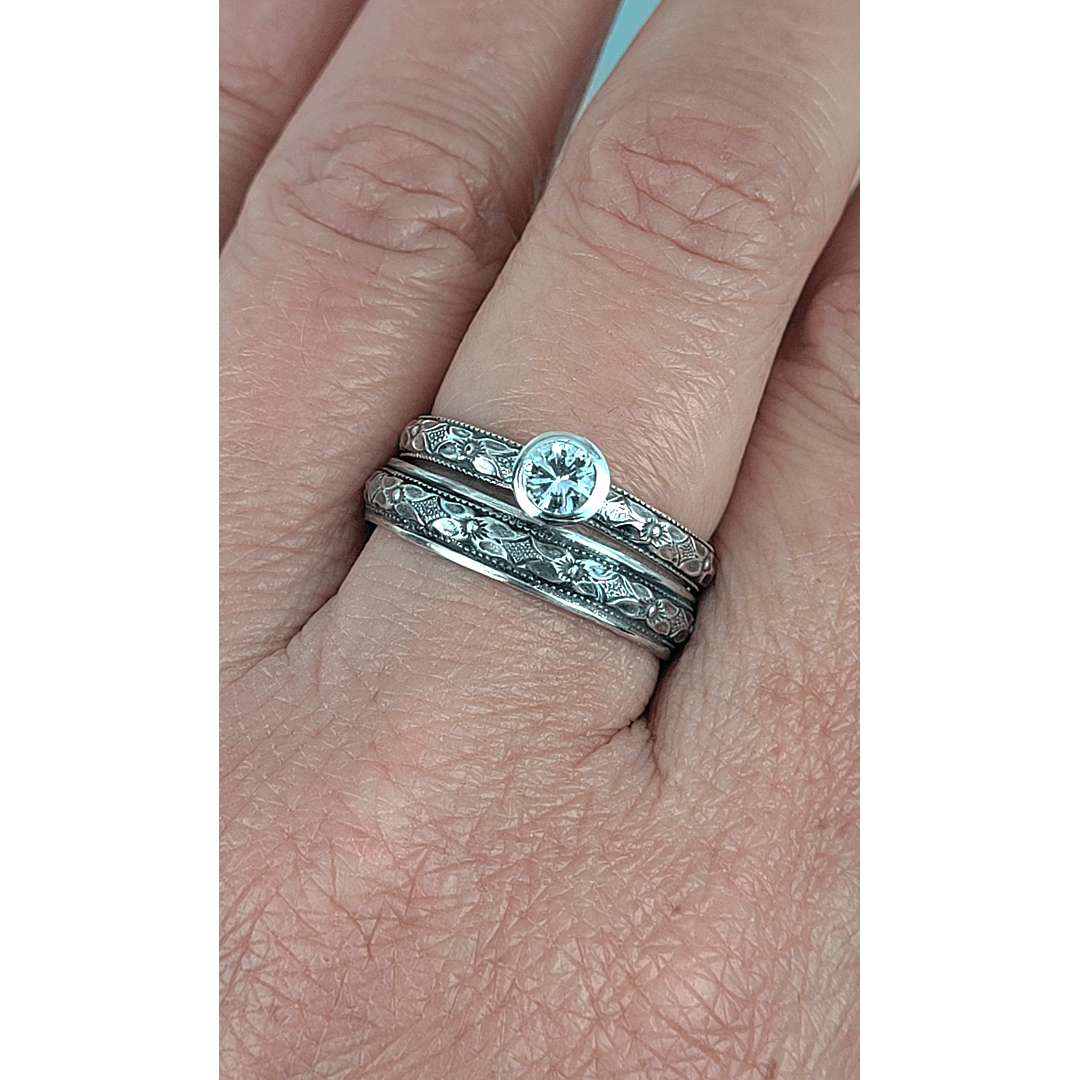 Vintage style white sapphire engagement ring and matching wedding band in sterling silver on model