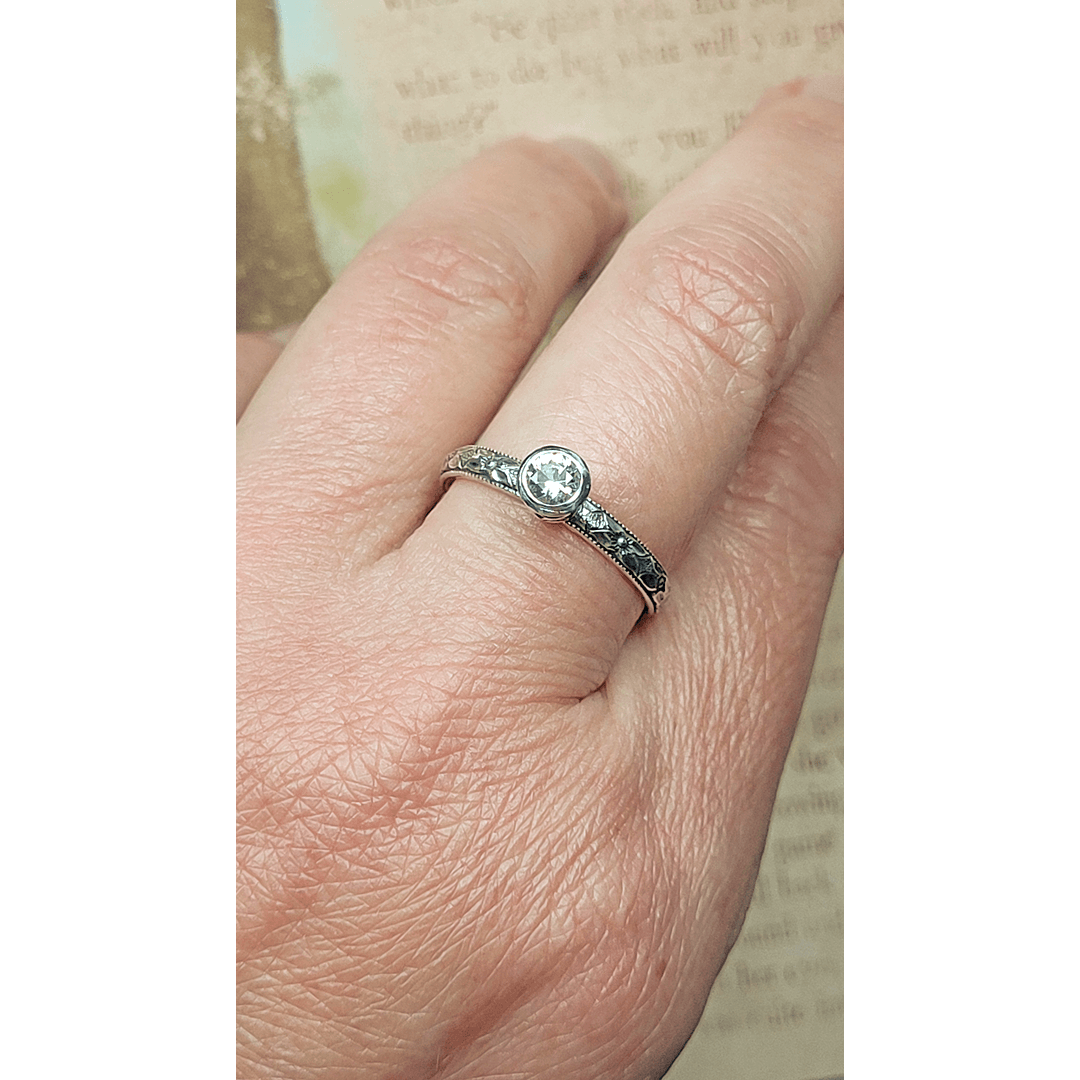 Vintage style white sapphire engagement ring in sterling silver on hand