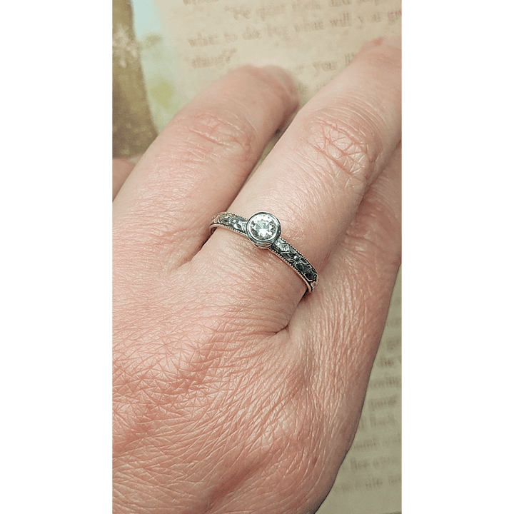 Vintage style white sapphire engagement ring in sterling silver on hand