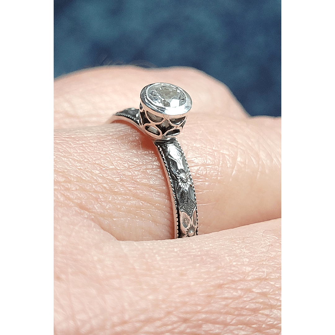 Vintage style white sapphire engagement ring with pierced bezel setting in sterling silver