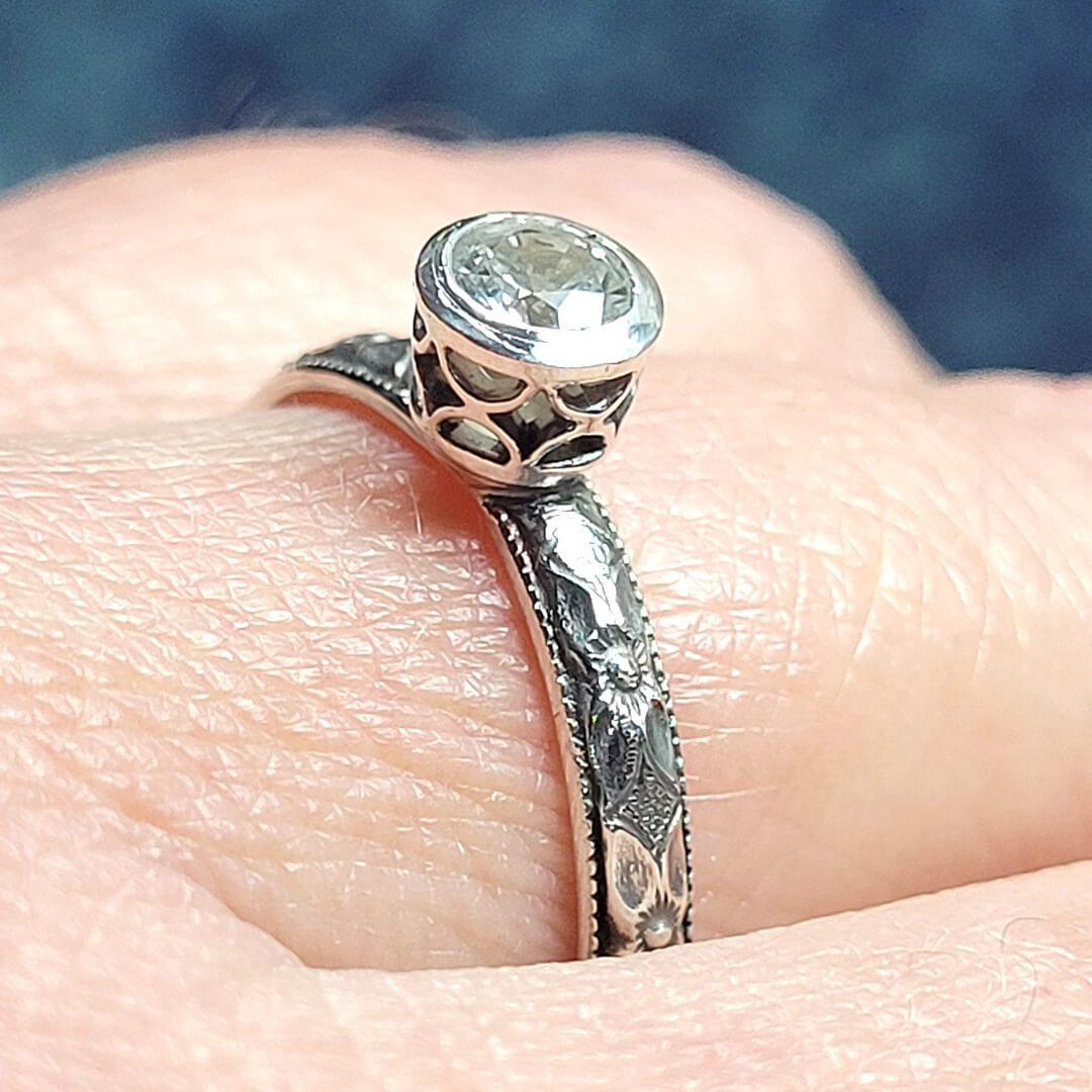 Vintage style white sapphire engagement ring with pierced bezel setting in sterling silver