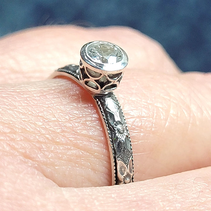 Vintage style white sapphire engagement ring with pierced bezel setting in sterling silver