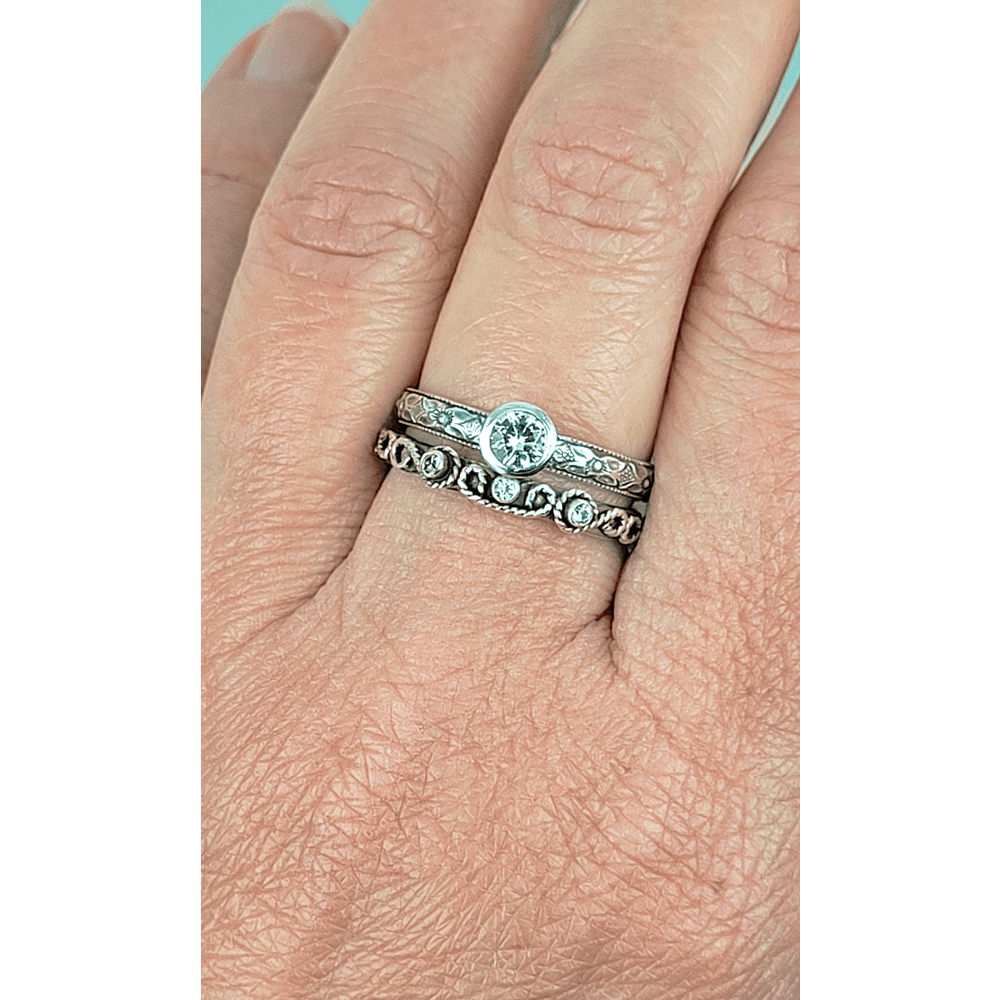 Vintage style white sapphire engagement ring and scrollwork white sapphire wedding band set in sterling silver on model