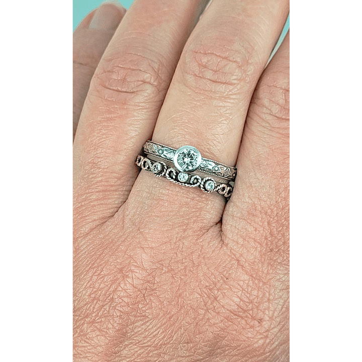 Vintage style white sapphire engagement ring and scrollwork white sapphire wedding band set in sterling silver on model