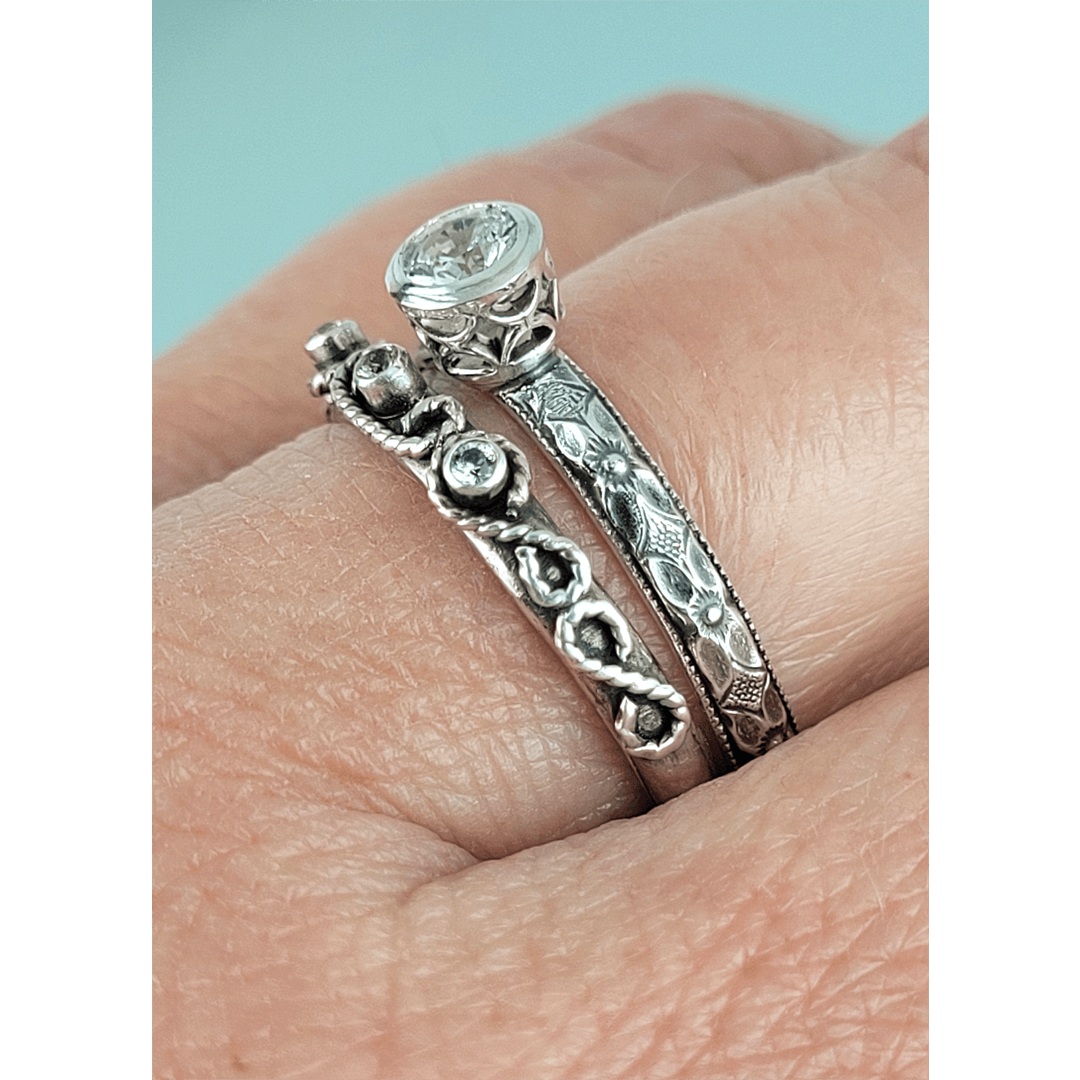 Vintage style white sapphire engagement ring and scrollwork white sapphire wedding band set in sterling silver on model side view