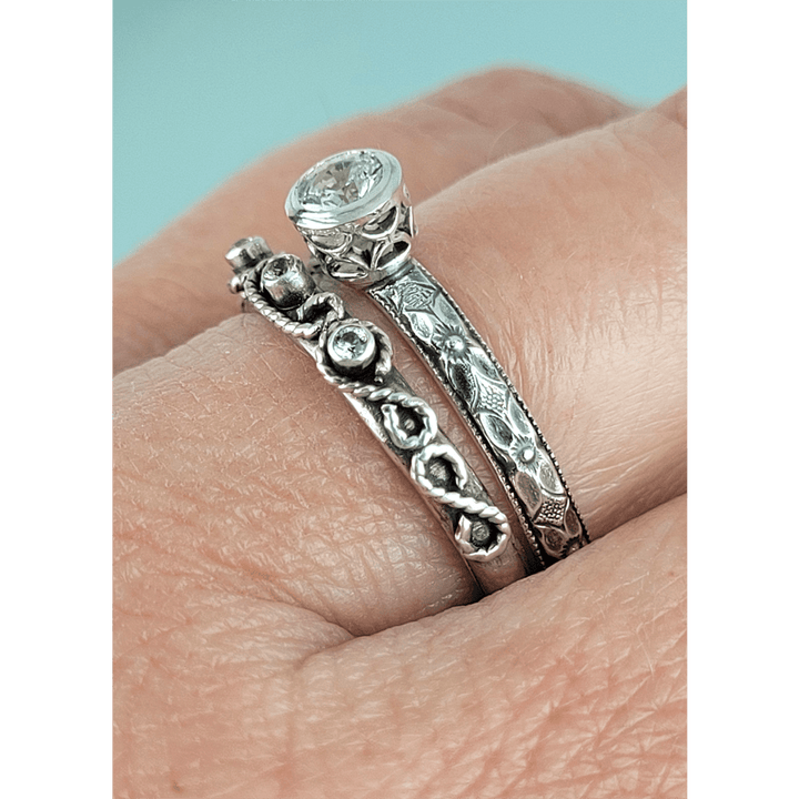 Vintage style white sapphire engagement ring and scrollwork white sapphire wedding band set in sterling silver on model side view