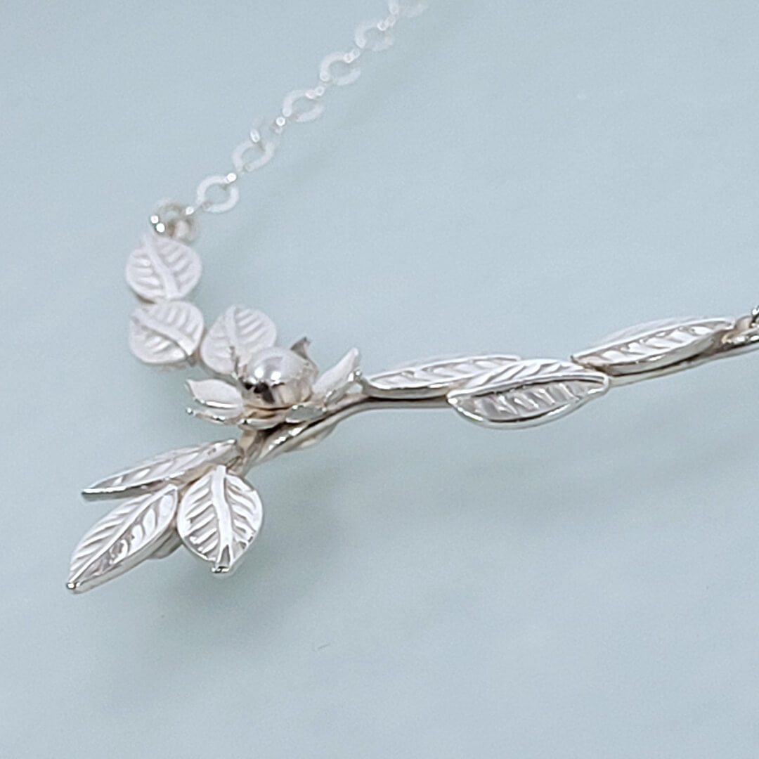 Close-up of flower and leaves necklace in sterling silver