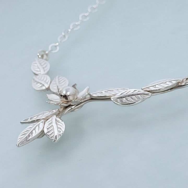 Close-up of flower and leaves necklace in sterling silver
