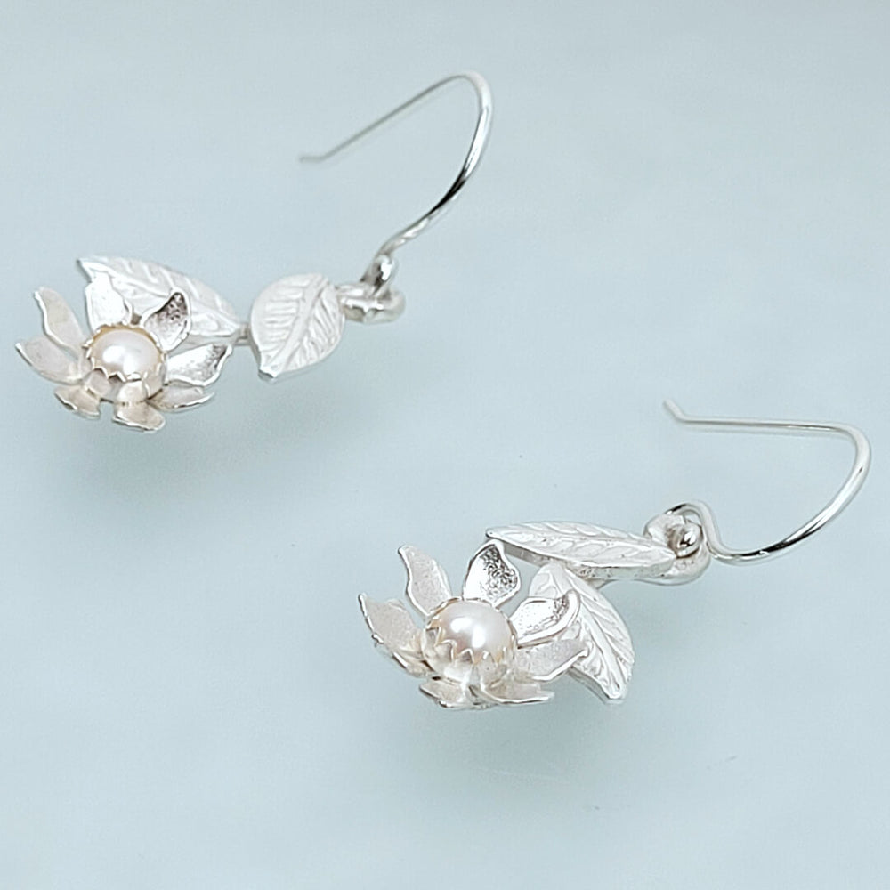 white wildflower dangle earrings in sterling silver set with pearls side view detail