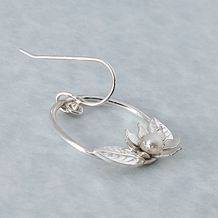 close-up of white wildflower hoop earrings in sterling silver with pearls