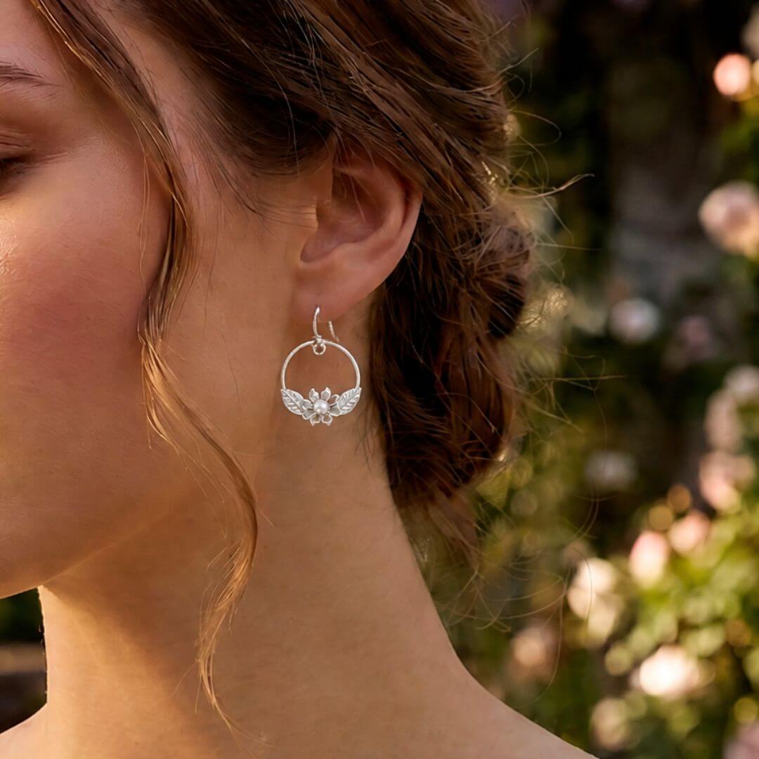 white wildflower hoop earrings in sterling silver set with pearl on model