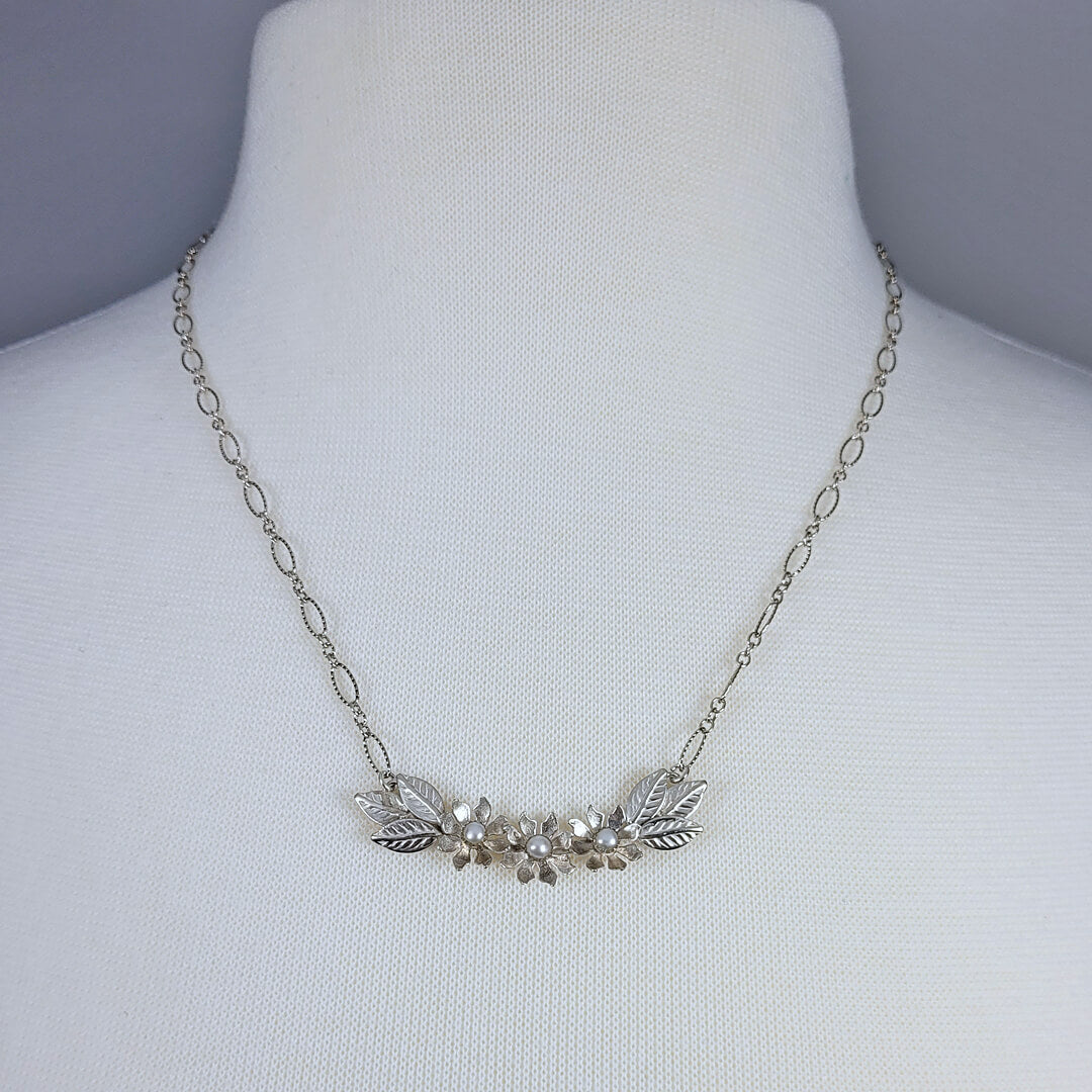 Handmade sterling silver wildflower crescent necklace with cultured freshwater pearls on mannequin