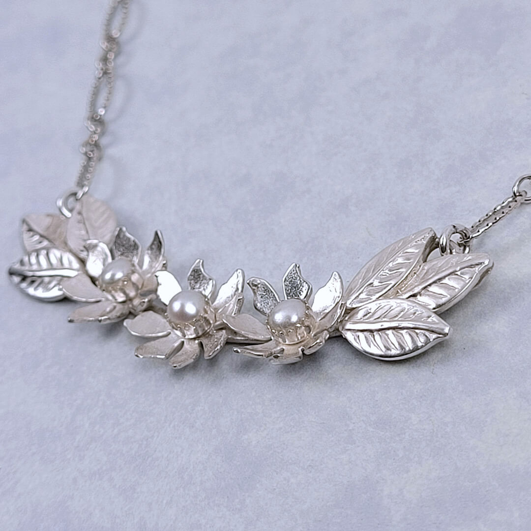 Handmade sterling silver wildflower crescent necklace set with cultured freshwater pearls close-up detail