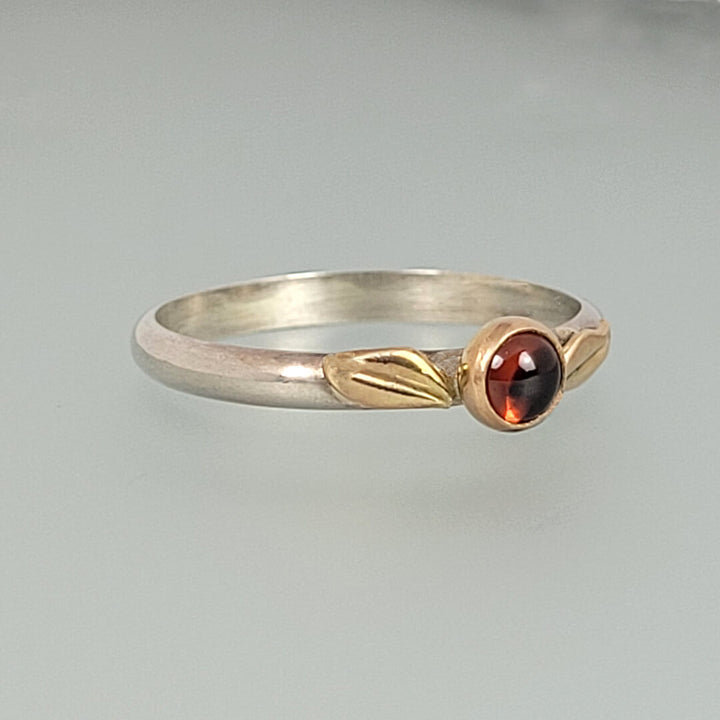 nature-inspired garnet ring with gold leaves on sterling silver  band